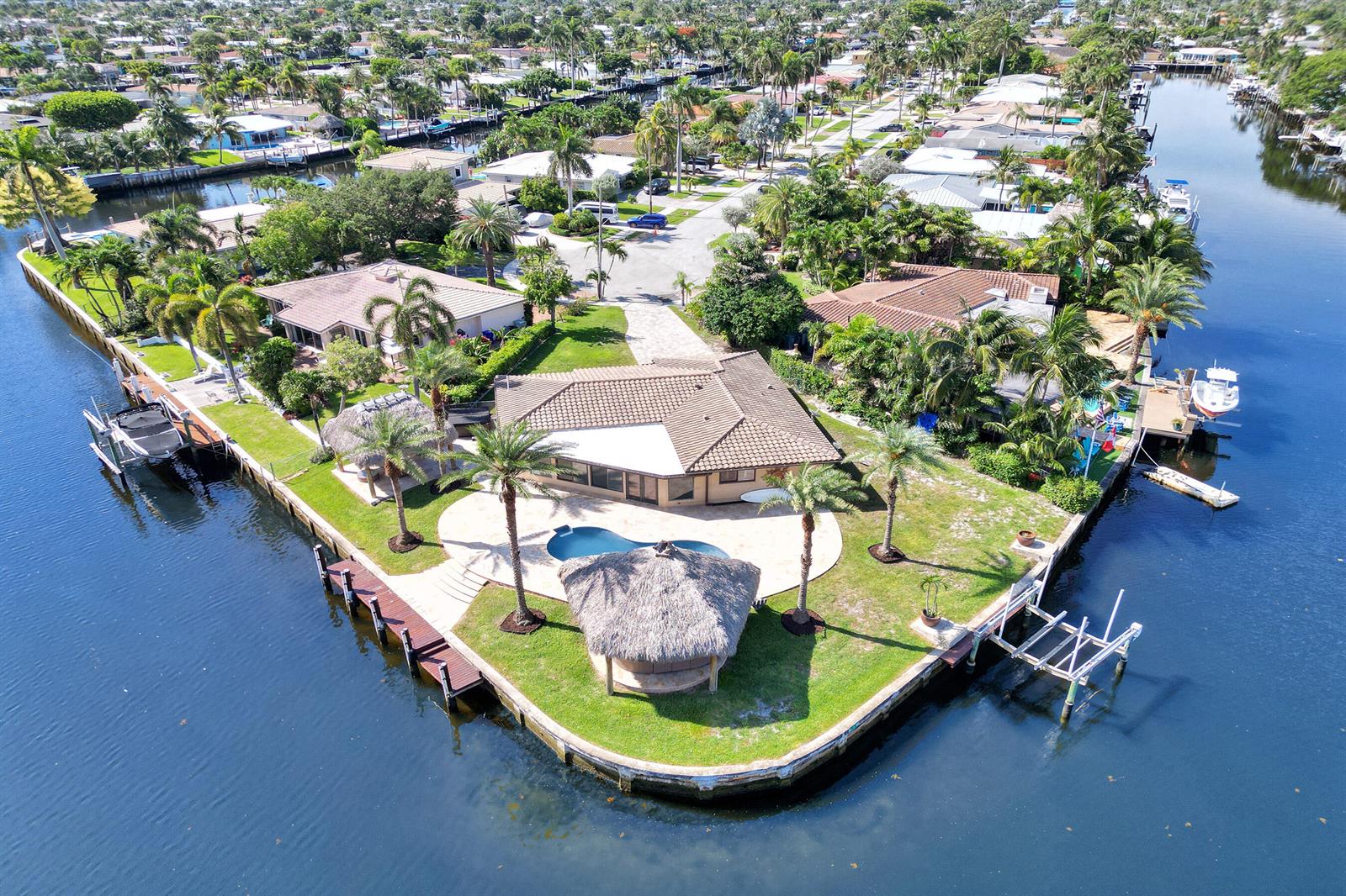 An aerial view of a waterfront house with a pool, tiki hut, and private dock — 271 SE 5th Terrace, Pompano Beach FL 33060, POMPANO BEACH, FL