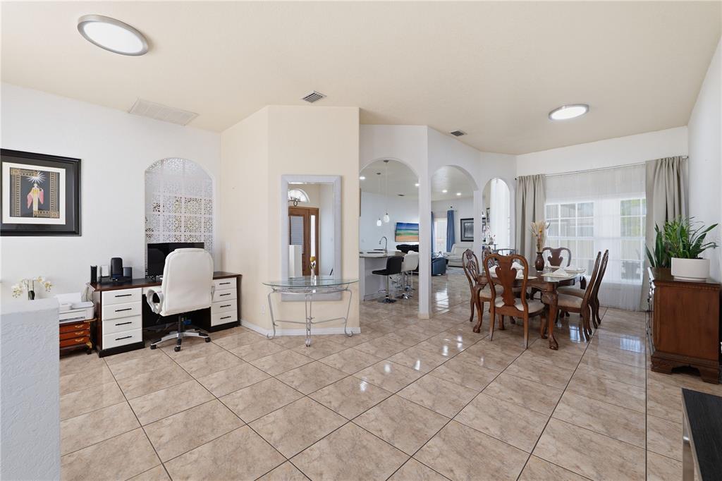 A tiled dining room and office area features arched doorways and a wooden dining set — 1907 W MOHAWK AVENUE, TAMPA, FL
