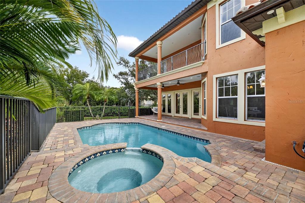 A two-story house with a pool and attached spa on a paved patio — 5910 LA ROSA LANE, APOLLO BEACH, FL