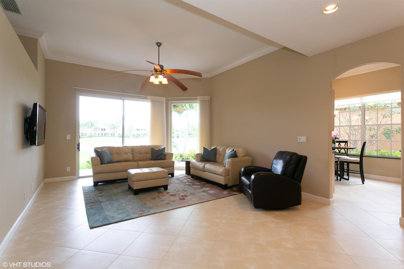 A living room with tile floors, two beige sofas, a leather recliner, and ceiling fan — 8407 Quail Meadow Way, West Palm Beach FL 33412, WEST PALM BEACH, FL