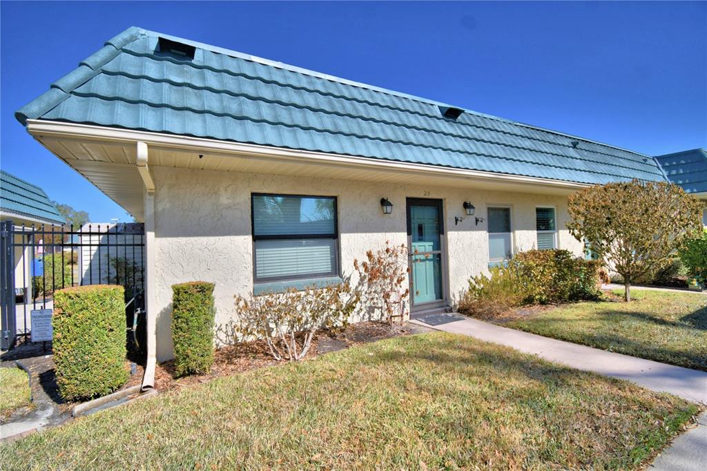 A single-story building with a blue metal roof and a beige stucco exterior — 345 24TH STREET NW UNIT 25, WINTER HAVEN, FL
