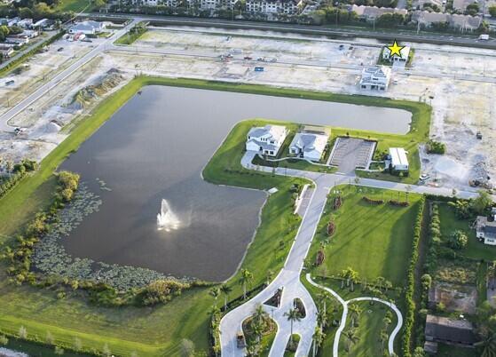 Aerial view of a residential development featuring a large pond, fountain, and several new homes — 5008 Naugle Way # 48, Davie FL 33328, DAVIE, FL