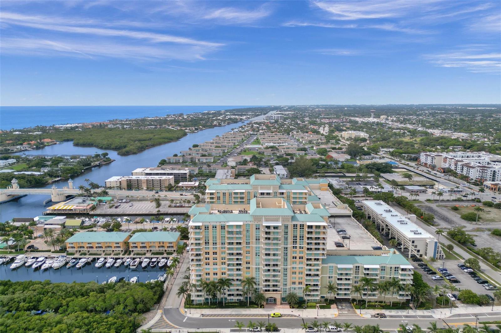 An aerial view of a large multi-story apartment complex situated near a coastal waterway — 700 E Boynton Beach Boulevard # 406, Boynton Beach FL 33435, BOYNTON BEACH, FL