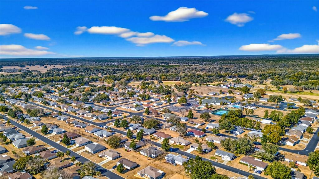 An aerial view shows a suburban neighborhood with many houses surrounded by trees and fields — 11335 SW 138TH LANE, DUNNELLON, FL