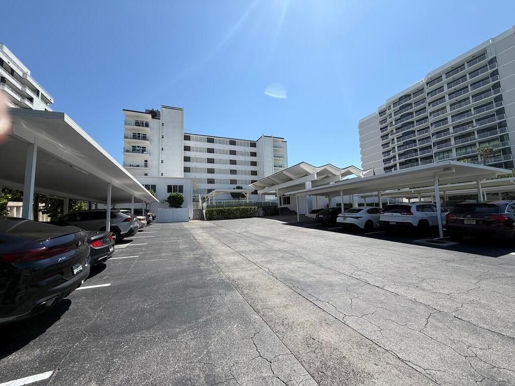 An outdoor parking lot with covered spaces sits between two large apartment buildings — 2909 S Ocean Boulevard # 6a, Highland Beach FL 33487, HIGHLAND BEACH, FL