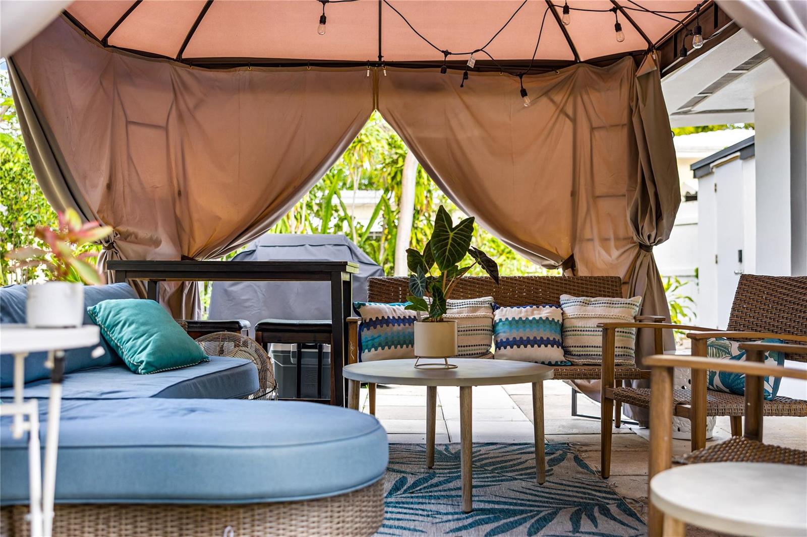 A covered outdoor patio features a sectional sofa, wicker chairs, and a central coffee table — 218 SW 7th Street, Dania Beach FL 33004, DANIA BEACH, FL