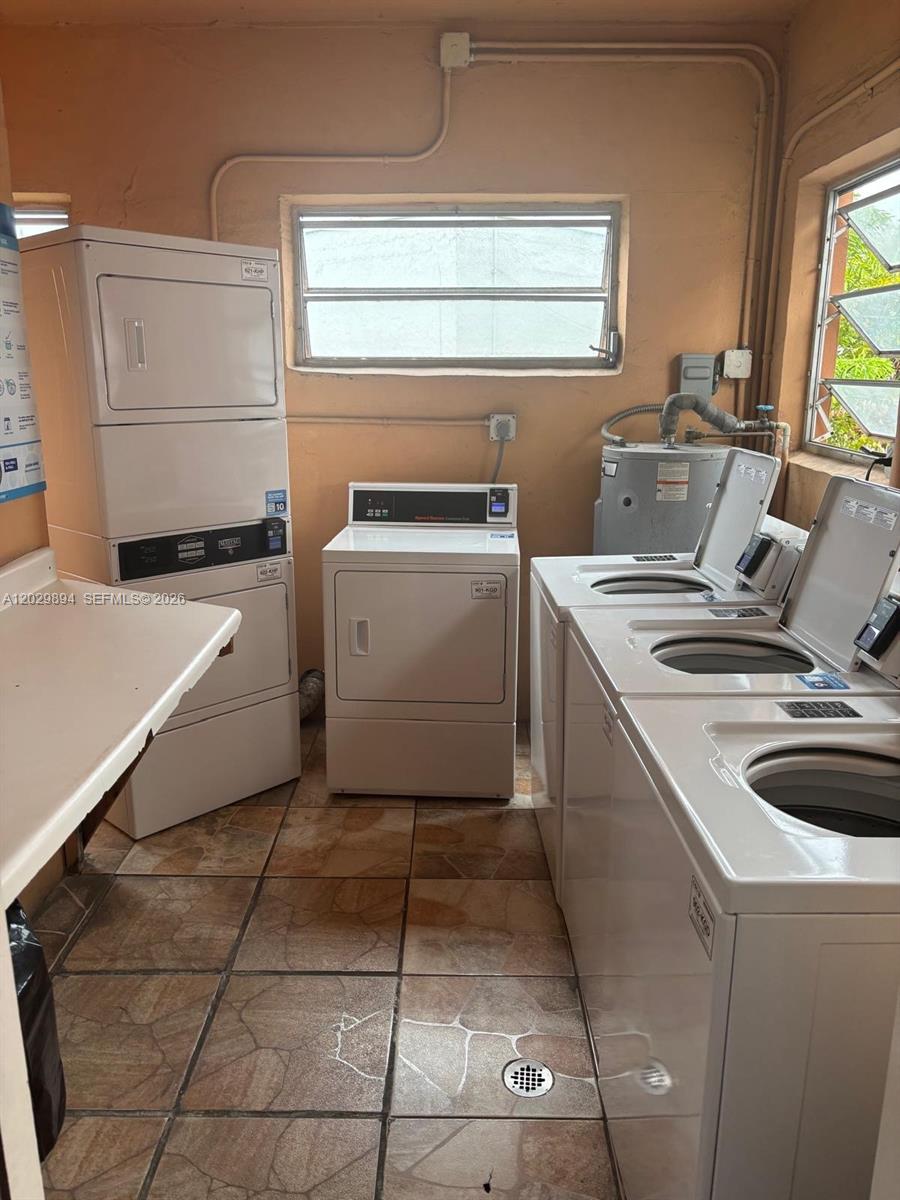 A laundry room features multiple white washers and dryers, tiled flooring, and a water heater — 6850 W 16th Dr # 317, Hialeah FL 33014, HIALEAH, FL