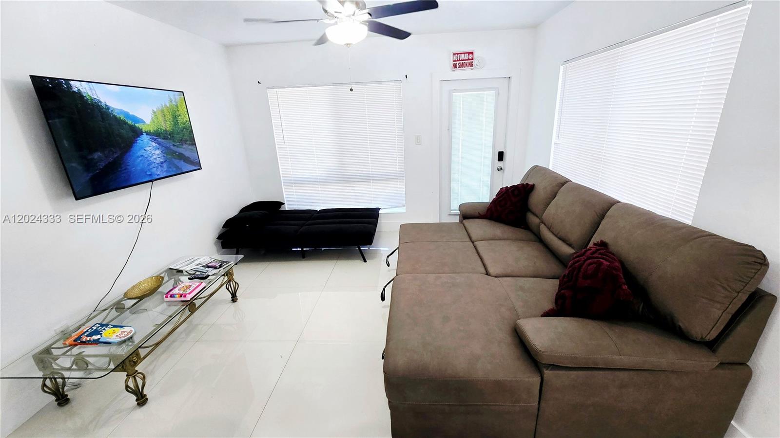 A living room features a brown sectional sofa, a glass coffee table, and a wall-mounted television — 139 NW 14th Way, Dania Beach FL 33004, DANIA BEACH, FL