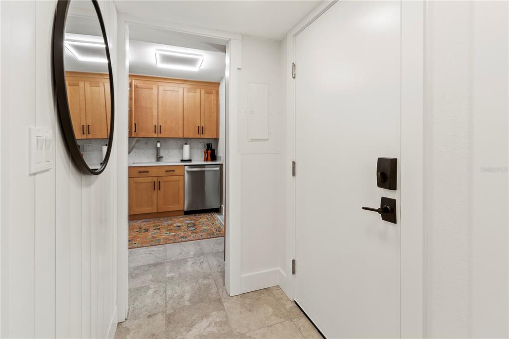 A view from a hallway looking into a kitchen with light wood cabinets and tile — 806 BAYPORT WAY UNIT 806, LONGBOAT KEY, FL