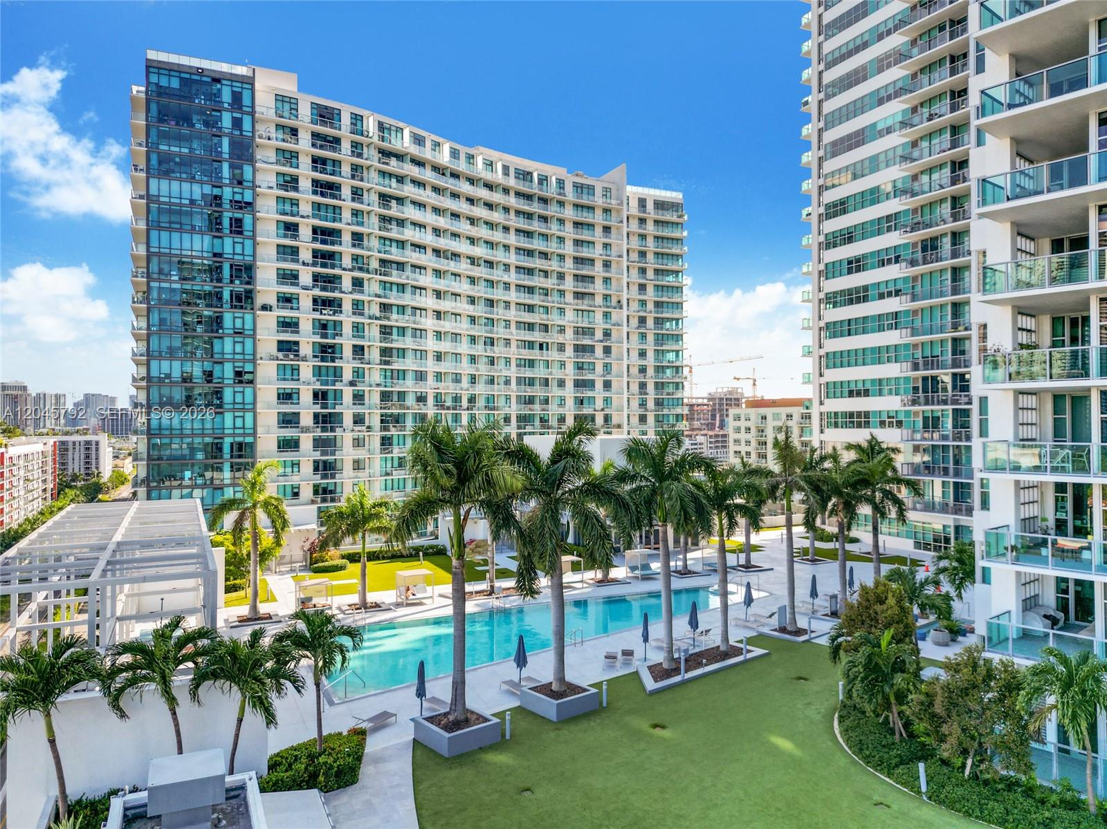 An outdoor swimming pool is surrounded by palm trees and high-rise apartment buildings — 3301 NE 1st Ave # M0705, Miami FL 33137, MIAMI, FL