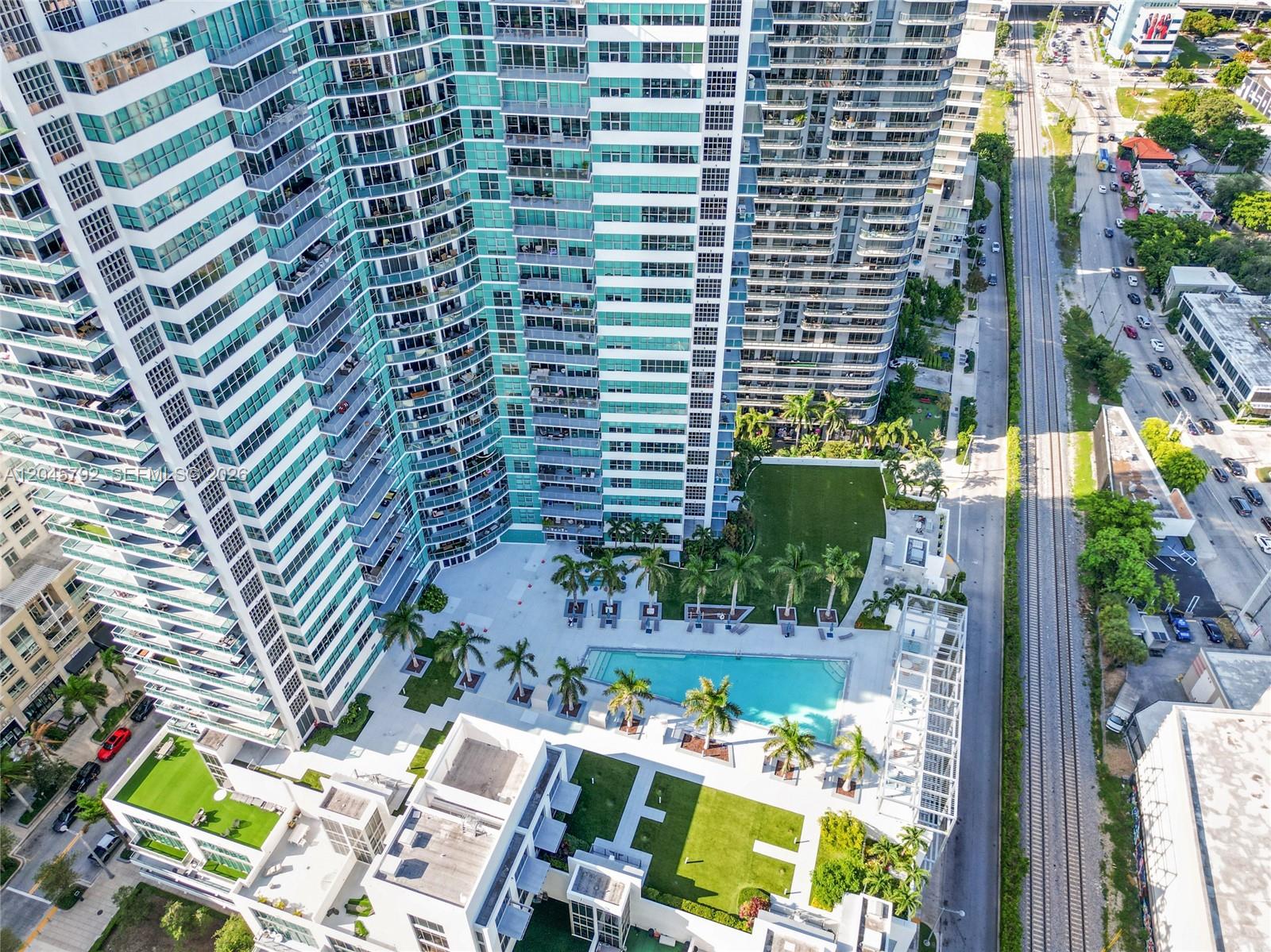 An aerial view shows a high-rise apartment complex with a swimming pool and courtyard — 3301 NE 1st Ave # M0705, Miami FL 33137, MIAMI, FL