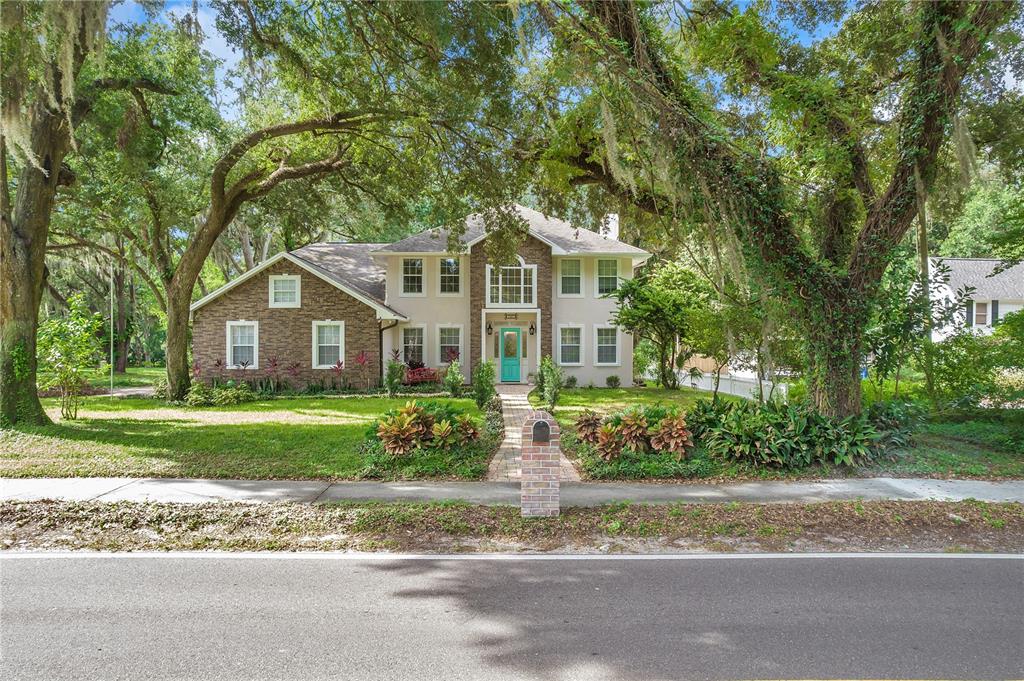 A two-story house with a brick facade, a teal front door, and a stone walkway — 1507 W WINDHORST ROAD, BRANDON, FL