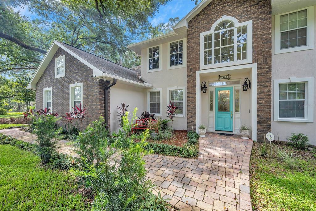 A side view of a house with a brick exterior, a garage, and a driveway — 1507 W WINDHORST ROAD, BRANDON, FL