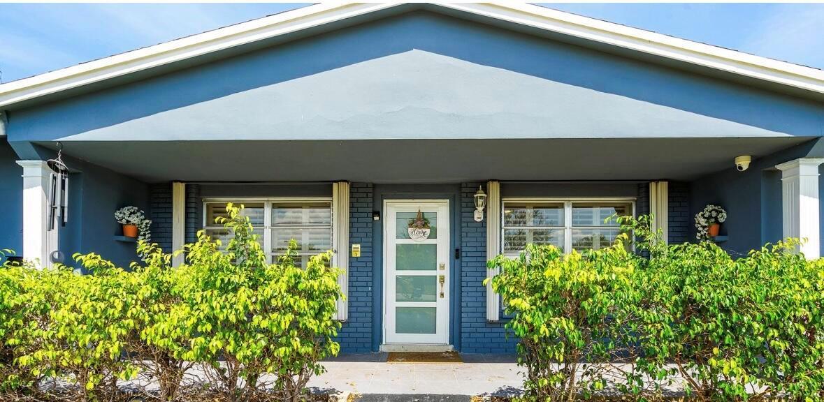 A blue house exterior features a covered front porch, white columns, and a glass-paneled door — 420 SE 12th Avenue, Deerfield Beach FL 33441, DEERFIELD BEACH, FL