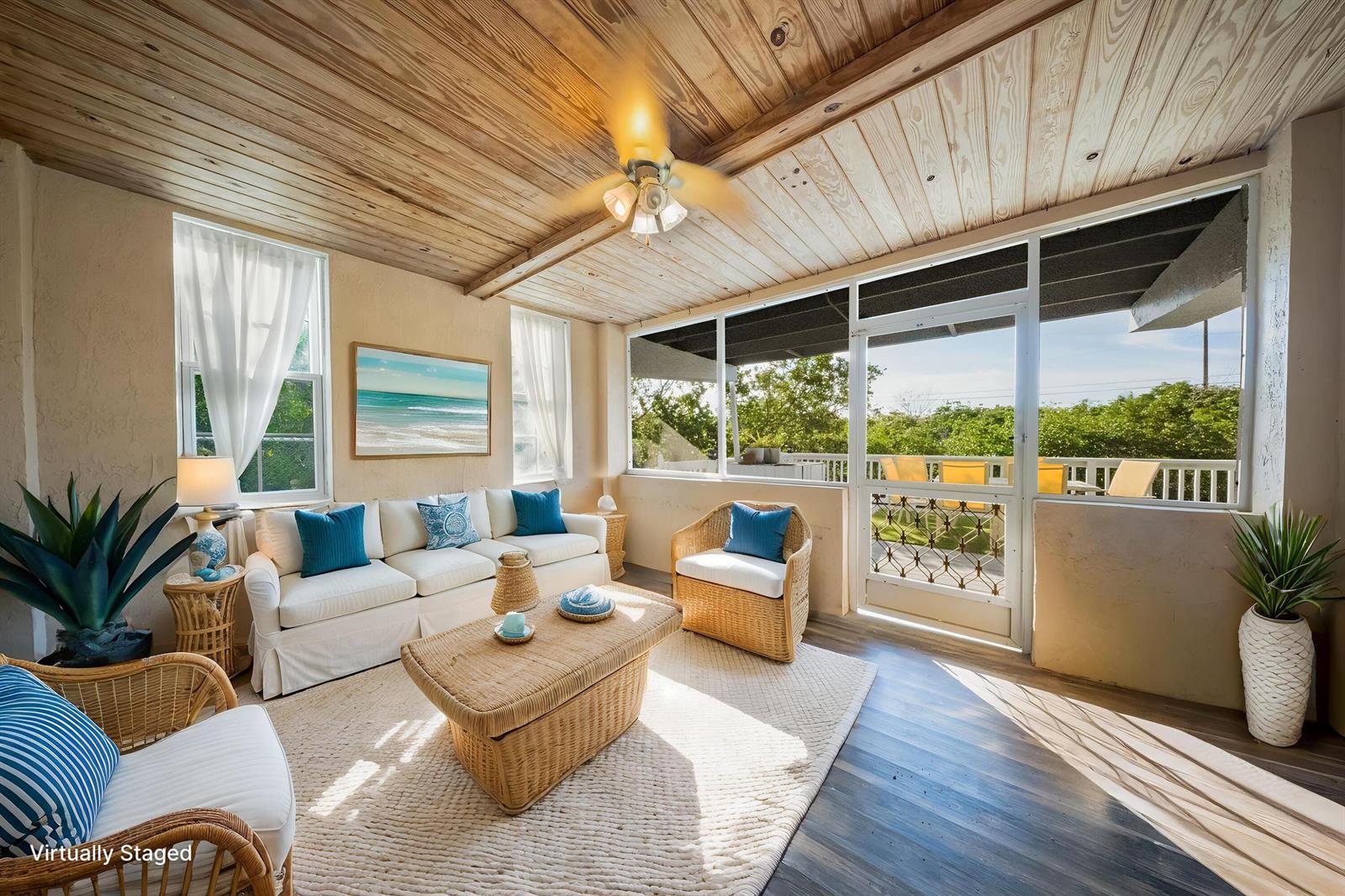 A sunroom features a wood-paneled ceiling, wicker furniture, and a door leading to a deck — 133 Valois Boulevard, Key Largo FL 33037, KEY LARGO, FL