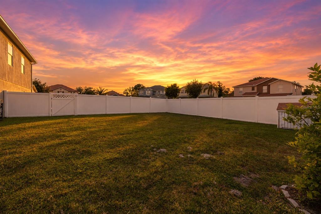 A two-story suburban house with a beige exterior, a two-car garage, and a front lawn — 831 NEPTUNE POINTE LANE, KISSIMMEE, FL
