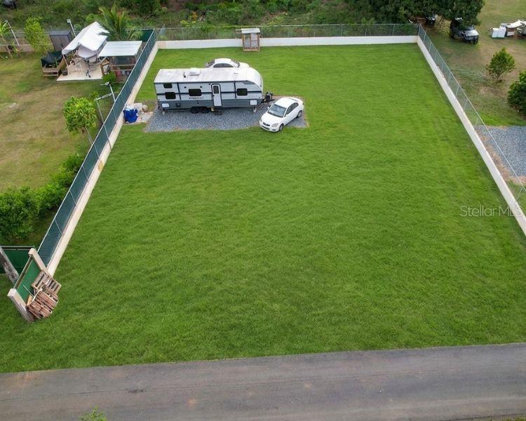 An aerial view shows a fenced grassy lot with a parked travel trailer and car — CARR 662 KM 2.1,  SANTANA, PR 00612, ARECIBO, PR