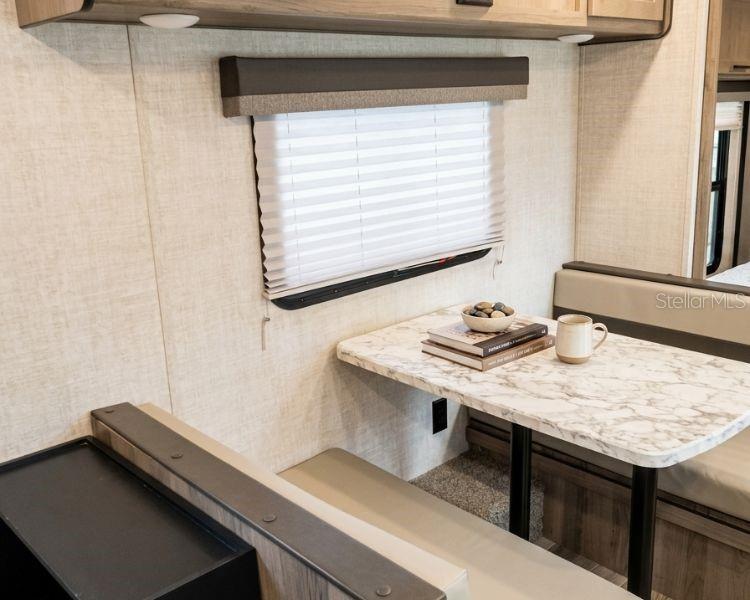 A dining area in a recreational vehicle features a marble-patterned table and pleated window blinds — CARR 662 KM 2.1,  SANTANA, PR 00612, ARECIBO, PR