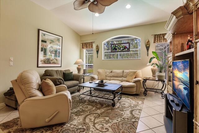 A living room features a beige sofa, a matching recliner, and a television on a stand — 23238 Marsh Landing Boulevard, FL 33928, FL