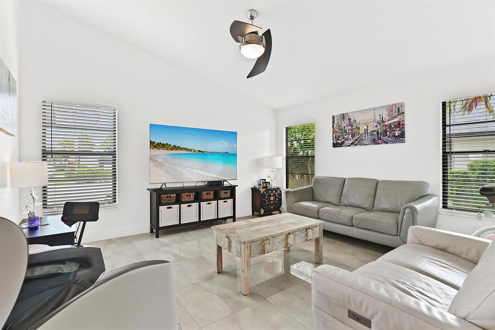 A living room features a television, two sofas, a coffee table, and tile flooring — 4383 Willow Pond Circle, West Palm Beach FL 33417, WEST PALM BEACH, FL