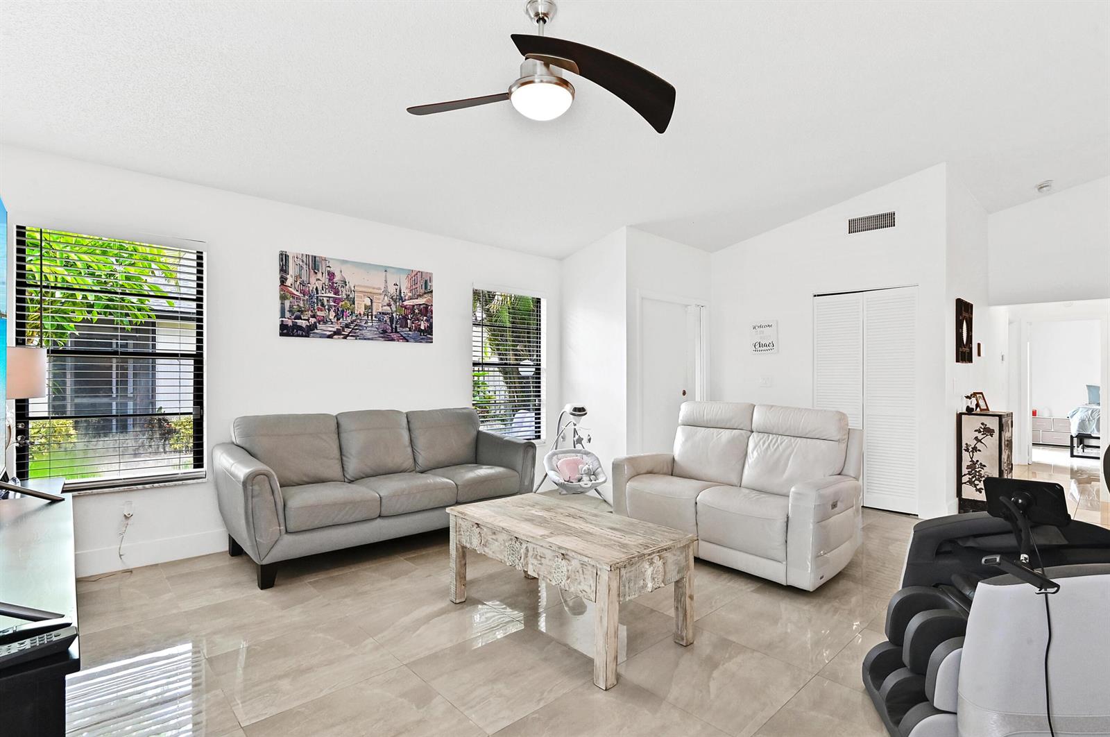 A living room features light tile floors, a ceiling fan, two sofas, and a coffee table — 4383 Willow Pond Circle, West Palm Beach FL 33417, WEST PALM BEACH, FL