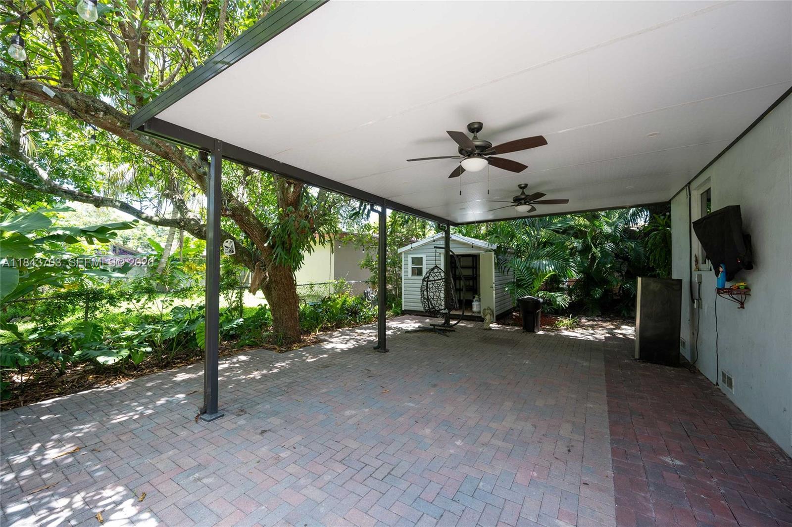 A covered patio features a brick paver floor, two ceiling fans, and a small storage shed — 13325 NE 10th Ave, North Miami FL 33161, NORTH MIAMI, FL