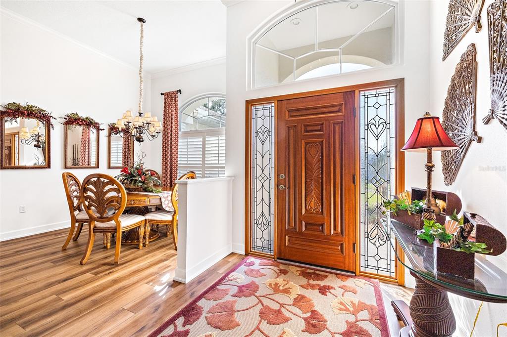 An entryway with a wooden front door and a dining area with wood-look flooring — 7042 MONTREAL DRIVE, LAKELAND, FL