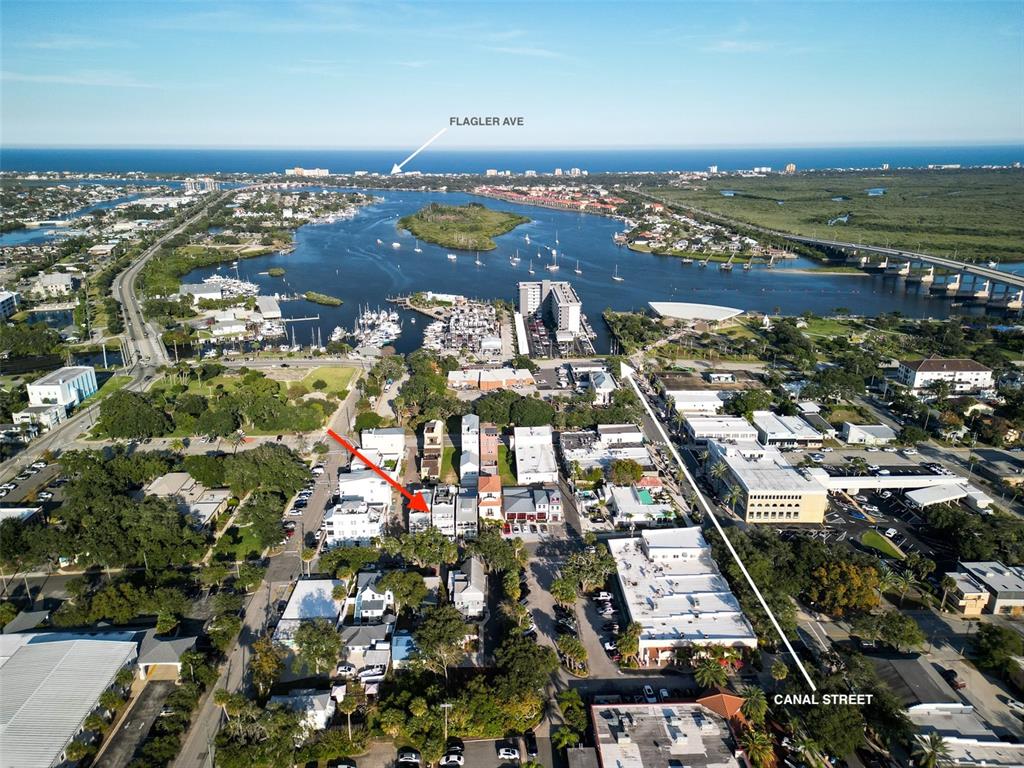 This aerial view shows a coastal town with a waterway, marina, and city streets — 119 FAULKNER STREET, NEW SMYRNA BEACH, FL