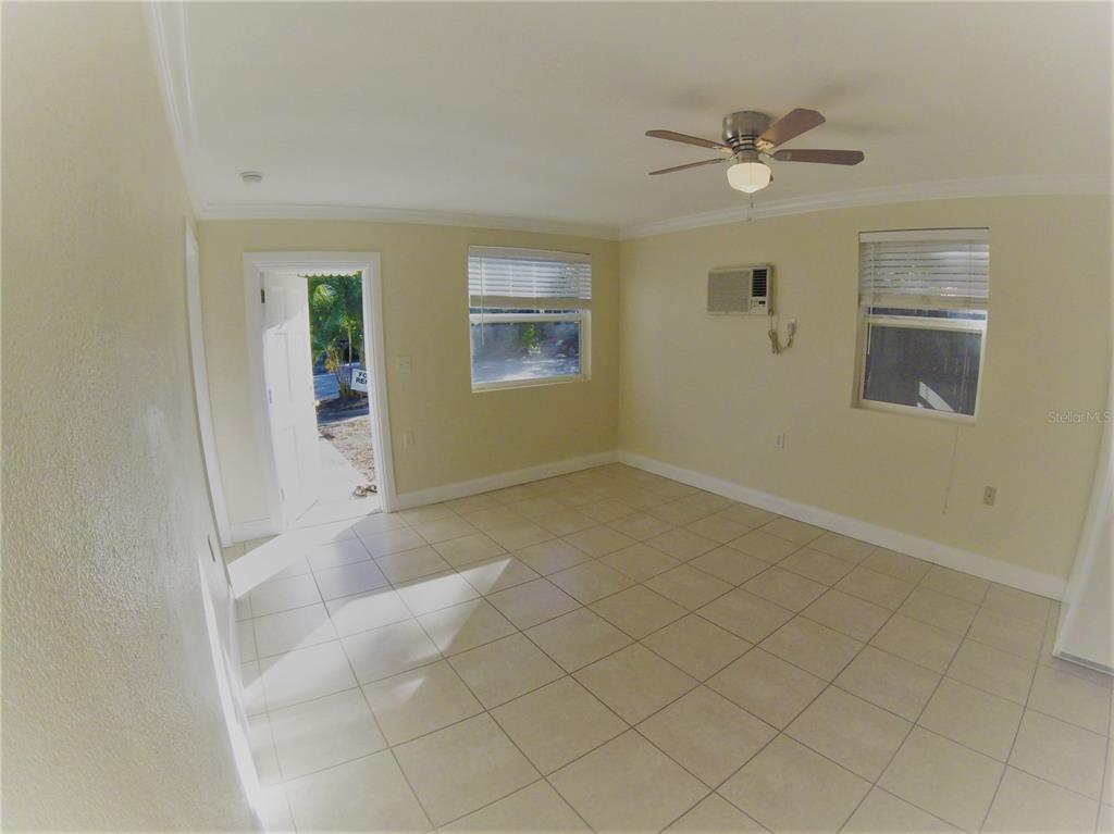 An empty room with light-colored tile flooring, a ceiling fan, and two windows — 1300 28TH AVENUE N UNIT 2, ST PETERSBURG, FL