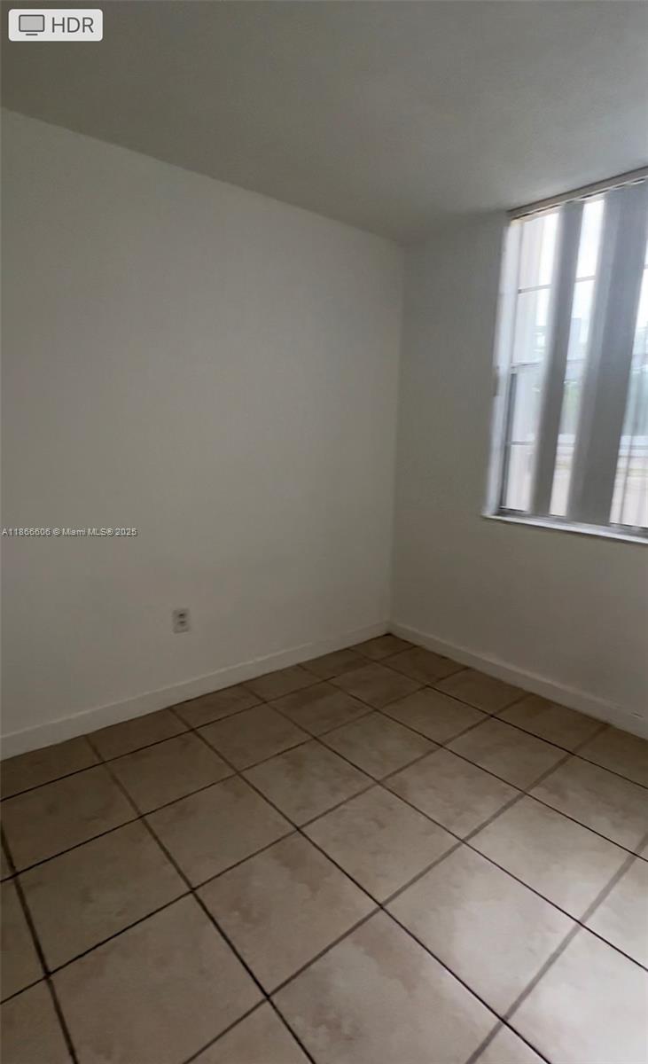 This is a small, empty room with white walls, tile flooring, and a window — 498 NW 165th St Rd # 101, Miami FL 33169, MIAMI, FL