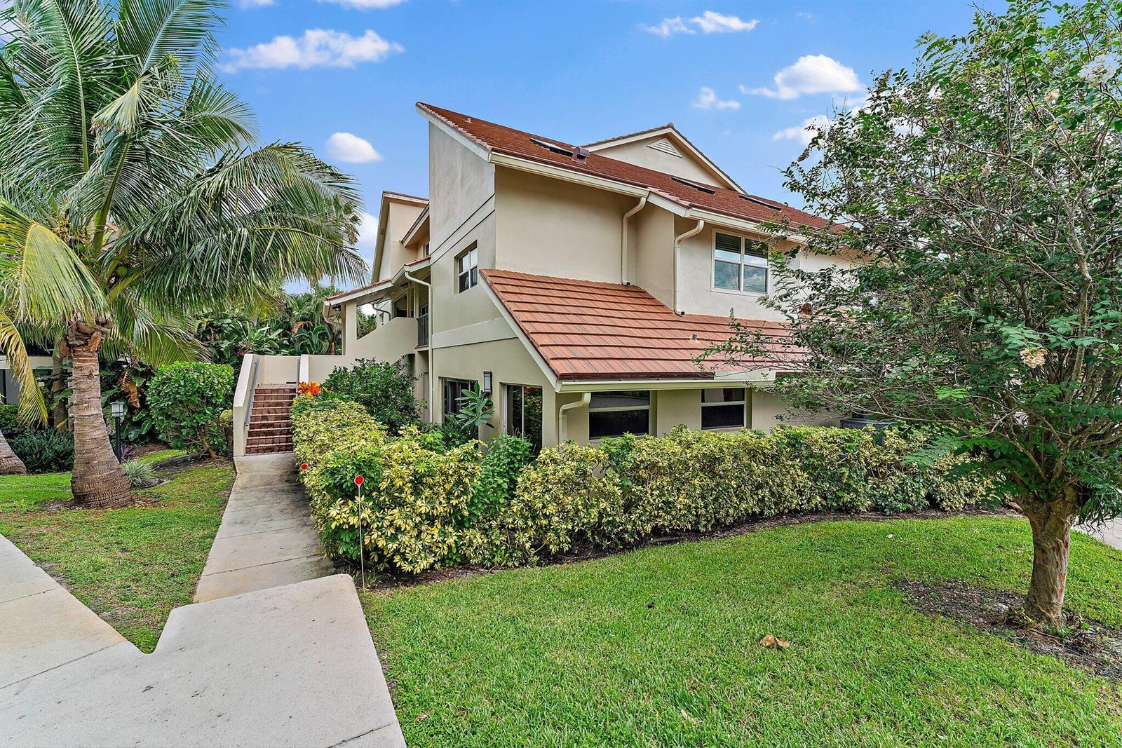 A two-story tan building with a red tile roof sits behind a manicured hedge — 4161 S Us Highway 1 # G3, Jupiter FL 33477, JUPITER, FL