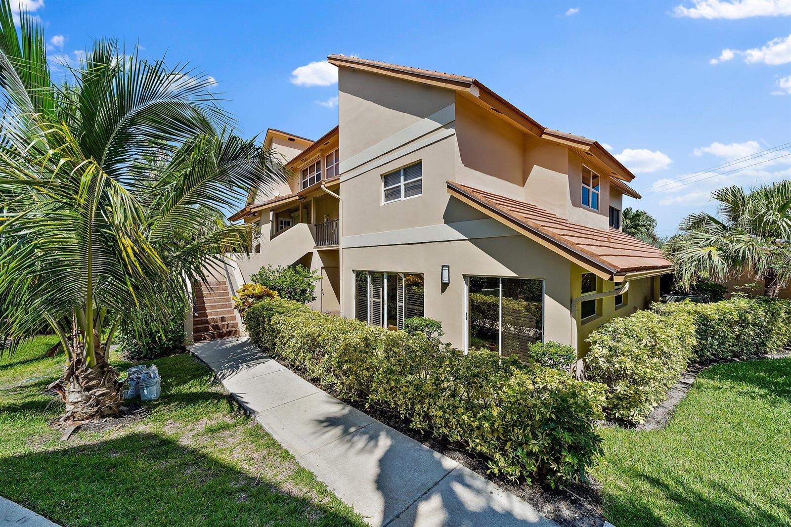 A multi-story tan stucco building with a tiled roof, a walkway, and surrounding landscaping — 4161 S Us Highway 1 # G3, Jupiter FL 33477, JUPITER, FL
