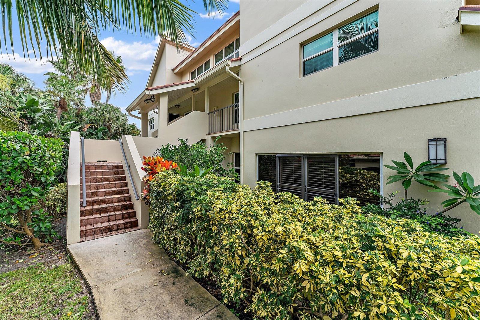 A concrete walkway leads to a set of stairs beside a multi-story beige building — 4161 S Us Highway 1 # G3, Jupiter FL 33477, JUPITER, FL