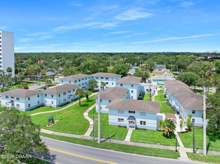 An aerial view shows several light blue apartment buildings with brown roofs and green lawns — 500 S BEACH STREET UNIT H2, DAYTONA BEACH, FL