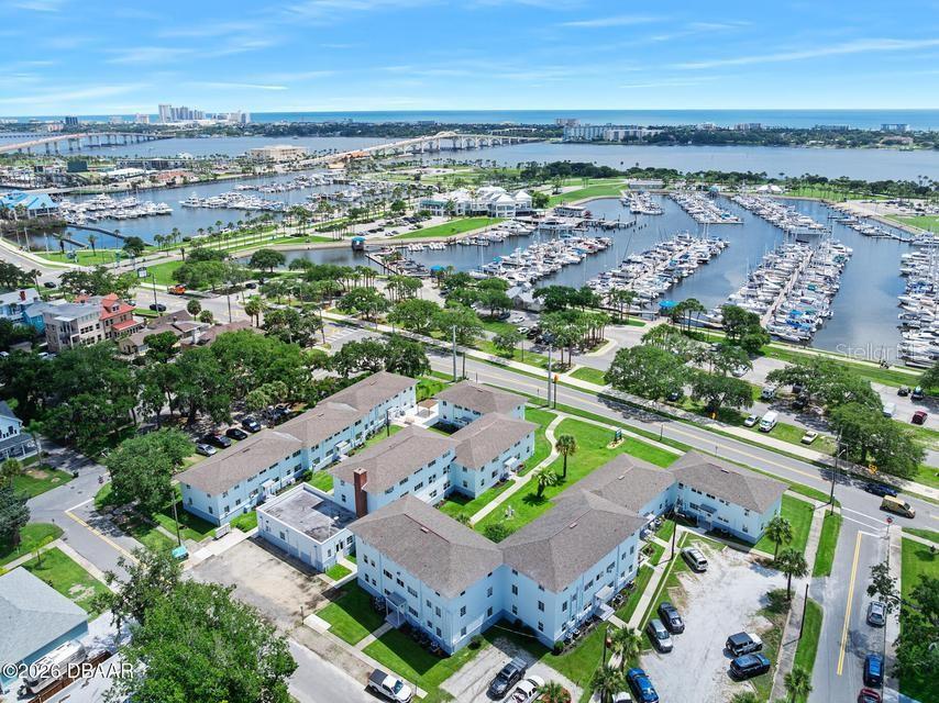 An aerial view shows a multi-story apartment complex near a marina and a coastal bridge — 500 S BEACH STREET UNIT H2, DAYTONA BEACH, FL
