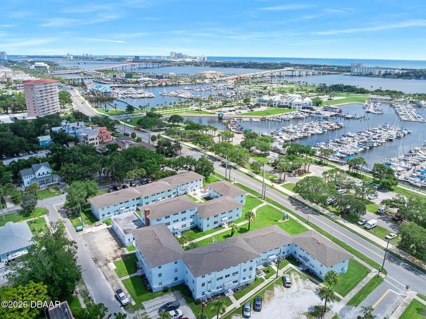 An aerial view shows a light blue apartment complex near a marina and bridge — 500 S BEACH STREET UNIT H2, DAYTONA BEACH, FL