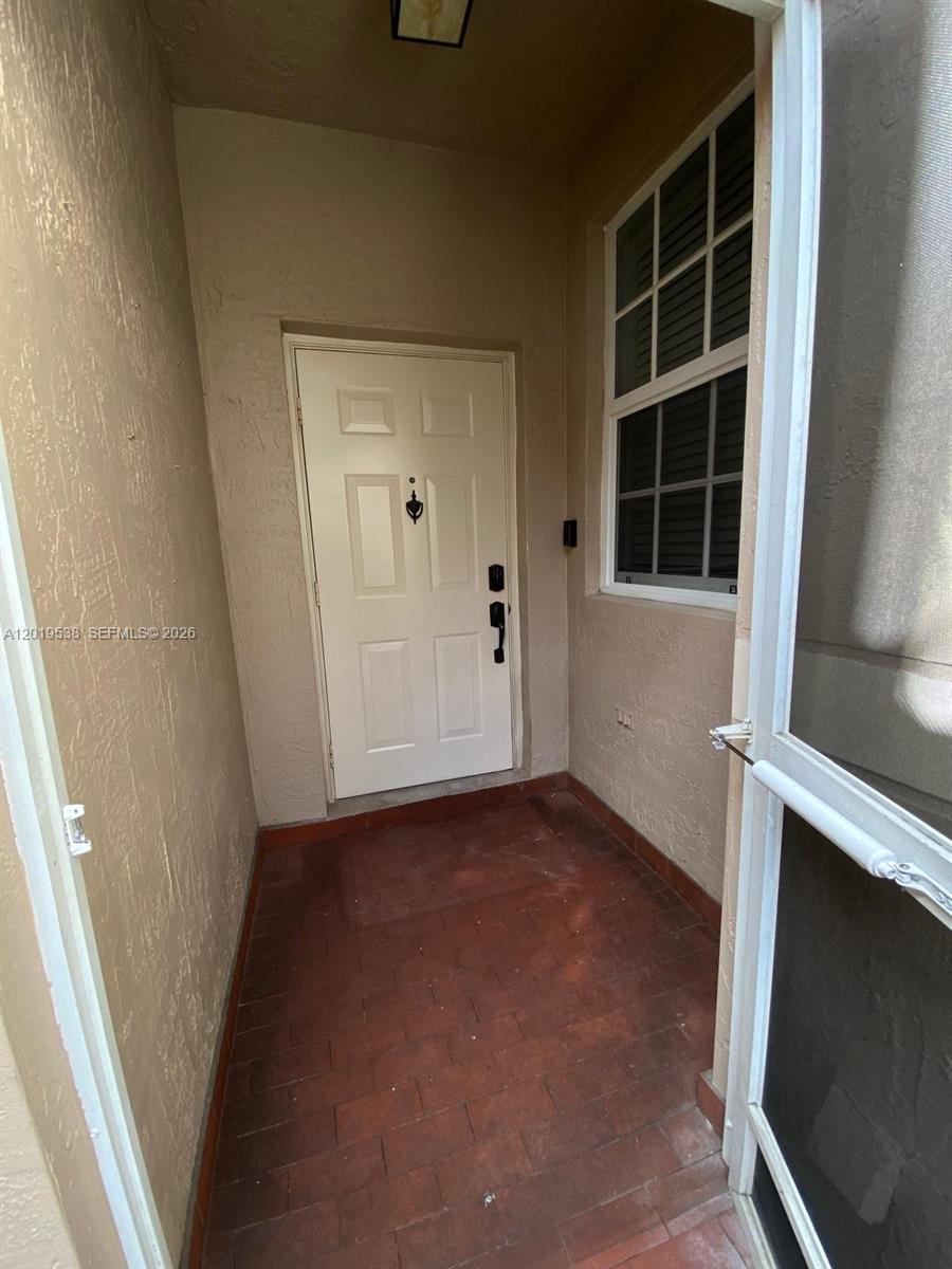 A view of a small, covered entryway with a white door and tiled floor — 2041 Pompeii Ct # 2014, Weston FL 33327, WESTON, FL