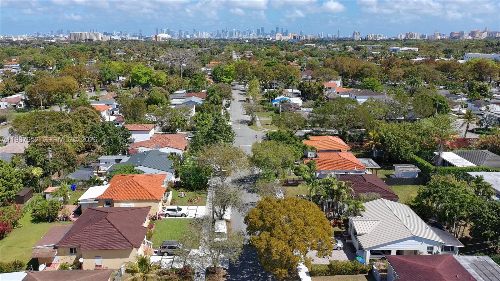 An aerial view shows a residential street lined with houses and trees under a city skyline — 5400 SW 5th Ter, Miami FL 33134, MIAMI, FL
