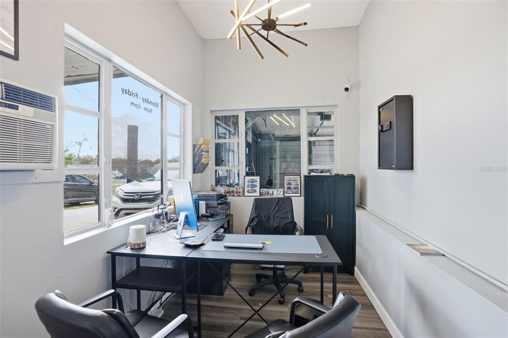 A small office features a desk, two chairs, a window, and a modern light fixture — 13379 CHAMBORD STREET, BROOKSVILLE, FL