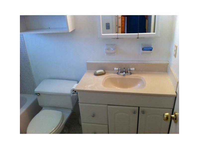 A bathroom features a white vanity with a beige countertop, a toilet, and a medicine cabinet — 4165 SW 67th Avenue # 107b, Davie FL 33314, DAVIE, FL