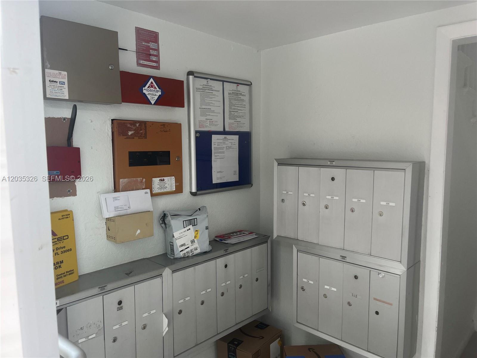 A small mailroom features wall-mounted metal mailboxes, electrical panels, and a bulletin board — 1550 Drexel Ave # 203, Miami Beach FL 33139, MIAMI BEACH, FL