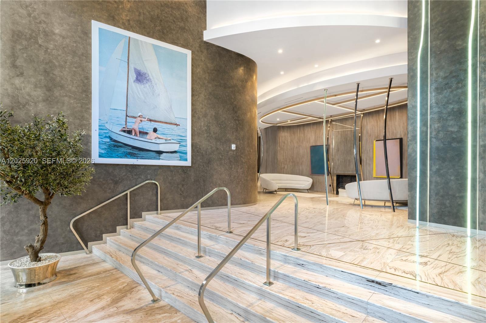 A modern lobby features marble stairs, a large sailboat painting, and curved seating areas — 1000 Brickell # 2014, Miami FL 33131, MIAMI, FL