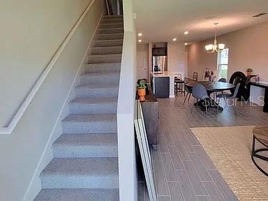 A staircase with gray carpeting leads to an open-concept kitchen and dining area — 1316 MIRABELLA CIRCLE, DAVENPORT, FL