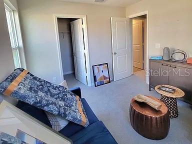 A bedroom features a blue sofa, a copper side table, and two open doorways — 1316 MIRABELLA CIRCLE, DAVENPORT, FL