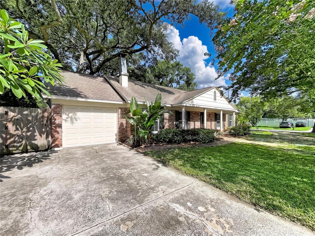 A single-story brick house with a garage, a covered front porch, and large shade trees — 3604 MARCO DRIVE, TAMPA, FL
