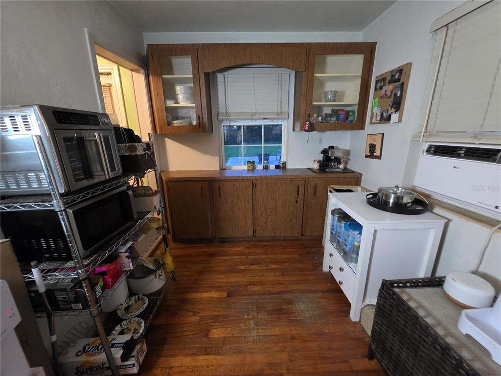 A kitchen features wood cabinets, a window, a metal shelving unit, and a white island — 1135 W GREENWOOD STREET, LAKELAND, FL