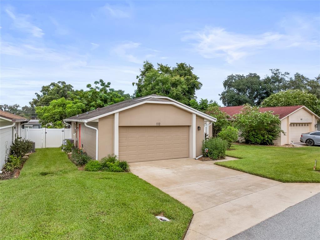 A tan single-story house with a two-car garage and a concrete driveway — 112 MAYFAIR CT, SANFORD, FL