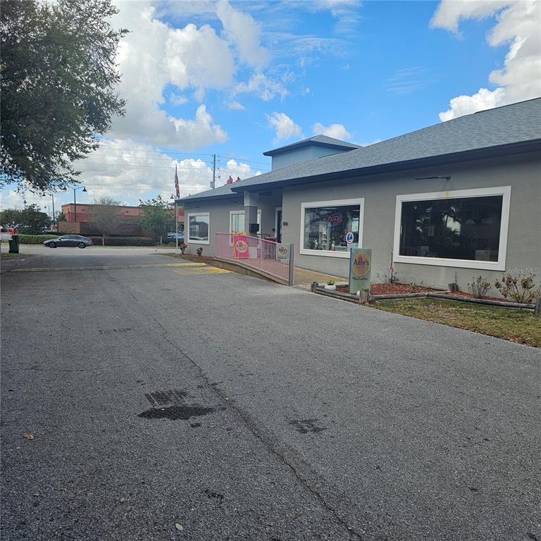 A gray commercial building with a ramp entrance and a parking lot in front — 1806 1ST STREET S UNIT 1, WINTER HAVEN, FL