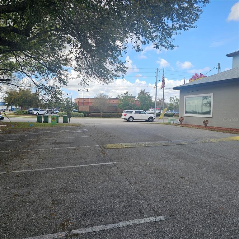 An outdoor parking lot sits in front of a building with a large window — 1806 1ST STREET S UNIT 1, WINTER HAVEN, FL