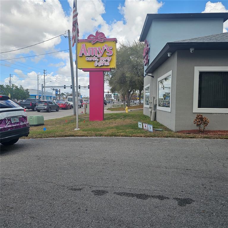 A pink sign for Amy's Cards, Party & Gifts stands outside a gray commercial building — 1806 1ST STREET S UNIT 1, WINTER HAVEN, FL